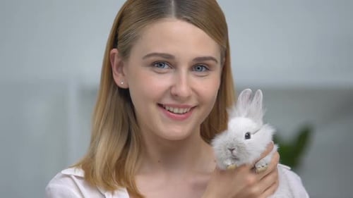 Woman Cradling Cute White Rabbit Indoors