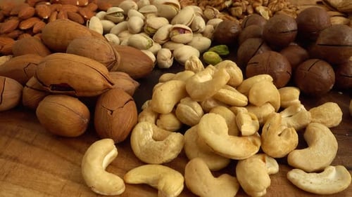 Assorted nuts on a wooden board.
