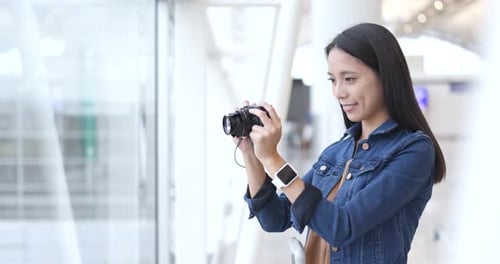 Woman Taking Photo on Camera in Airport
