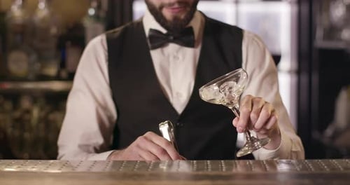 Bartender Adds Ice to Coupe Glass