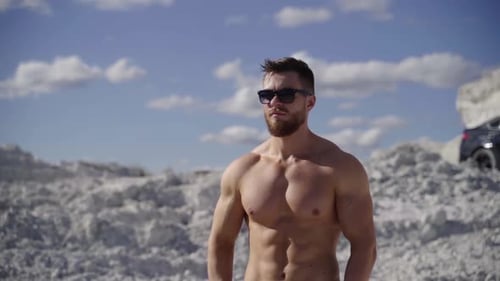 Muscular Man Posing Shirtless Near Rocks