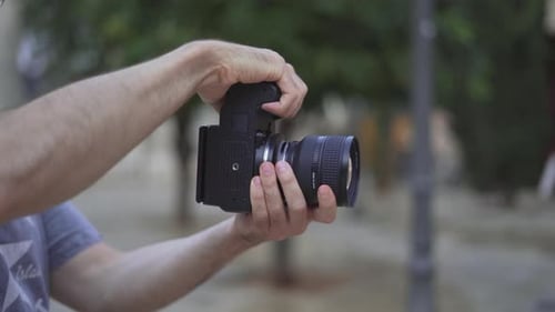 Person Holding a Camera Outdoors in Daylight