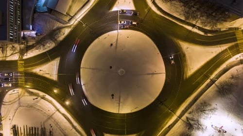 Illuminated Traffic Circle in the City and Cars at Winter Night. Round Crossroads. Aerial View