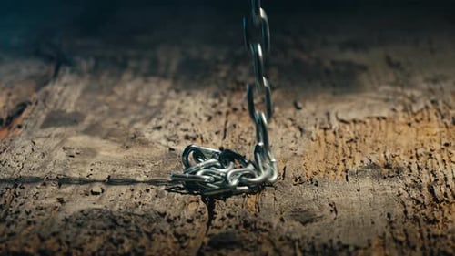 Metal Chain Falling Onto Distressed Wood Surface