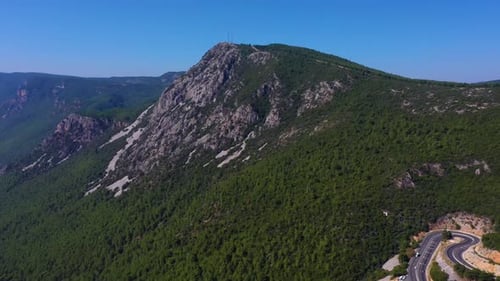 Vista panorámica aérea de montañas boscosas y sinuoso camino serpenteante