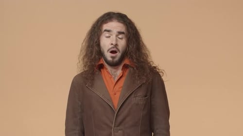 Man with Long Hair Yawns in Studio