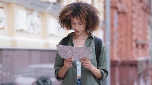 Young Woman Using Paper Map in City