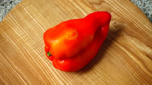 Shiny Red Pepper on a Cutting Board