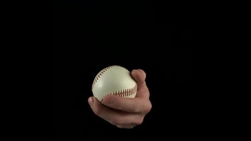 Hand Tossing Baseball Ball on Black Background