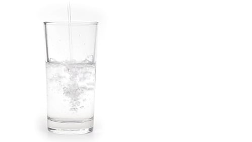 Water Pours Into Glass With Ice
