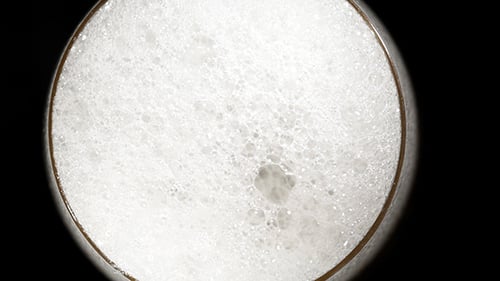 Beer Pours In Glass On Black