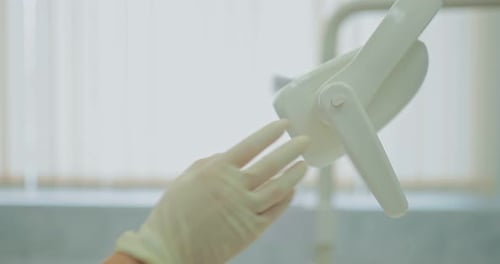 Dentist Adjusts Surgical Light Before Procedure