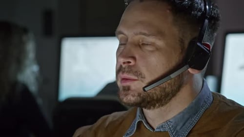 Man Wearing Headset in Dark Office Environment