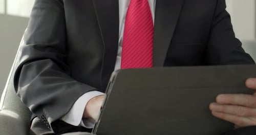 Geschäftsmann arbeitet auf Tablet-Computer in Bürolobby