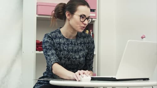 Smiling Young Woman Talks at Laptop Indoors