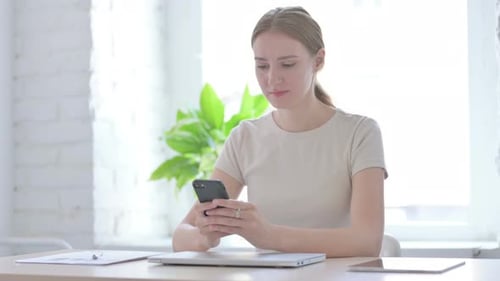Woman Uses Smartphone and Reacts Negatively