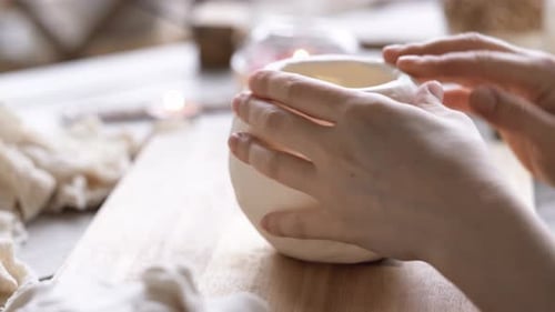 Hands Shaping Clay Pot in Home Studio