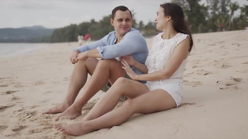 Young Lovers Tourists Sitting on Beach