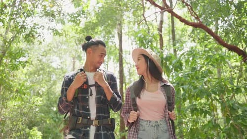 Attractive young couple traveler walking and exploring nature forest wild with happiness on holiday