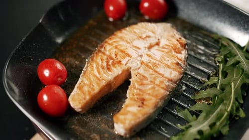 A Salmon Fillets on a Grill Plate with Herbs and Vegetables