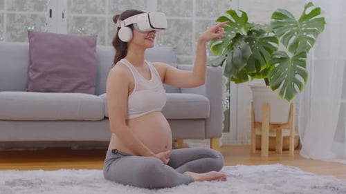 Pregnant Woman Using Virtual Reality Headset in Home