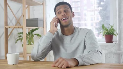 Young Adult Talking on Smartphone Indoors