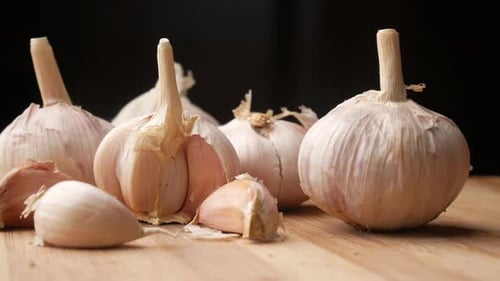 Close Up Pf Garlic on a Chopping Board Against Black Background