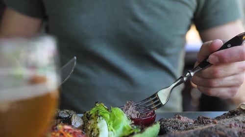 Man Eating Dinner In Restaurant. Closeup Man Eating Steak Meat