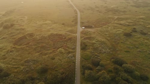 Beautiful Aerial Shot of Long Country Road Surrounded By Lush Fields Jutland