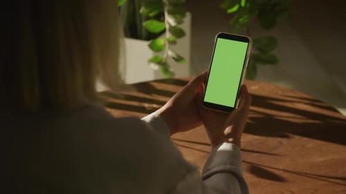 Handheld Close Up Shot of a Woman Holding Vertical Smart Phone with Green Screen Chroma Key
