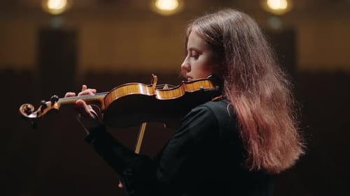 Young Female Violin Player is Practicing to Play Violin in Music Hall Portrait of Female Violinist