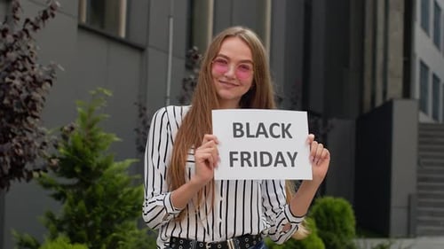 Woman Holding Black Friday Sale Sign Outside