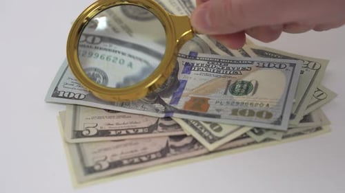 Close Up of Magnifying Glass Inspecting US Currency