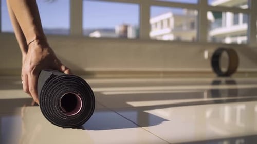 Barefoot Woman Puts and Unrolls Colorful Mat on Gym Floor