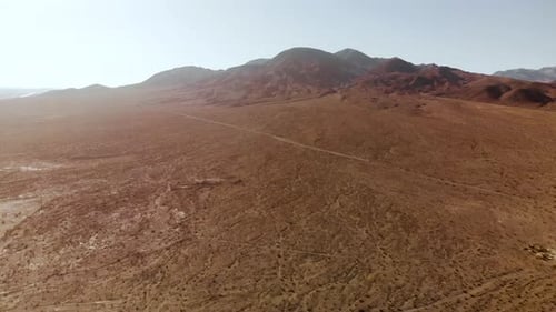 Aerial shots of the barren, sandy, rocky, mountain filled, Mojave Desert on a sunny day.