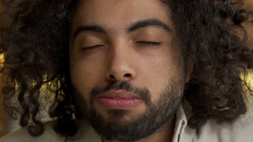 Man Eating Snack with Eyes Closed, Close Up