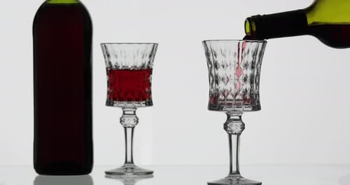 Vinho rosé. Vinho tinto despeje no copo de vinho sobre fundo branco