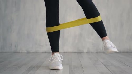 Female Exercising Fitness Elastic Resistant Band, Close Up of Legs