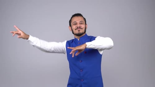Happy Indian man doing Indian folk dance bhangra and cheering up everybody in an Indian outfit
