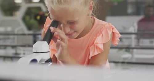 Video of happy caucasian girl with microscope during lesson