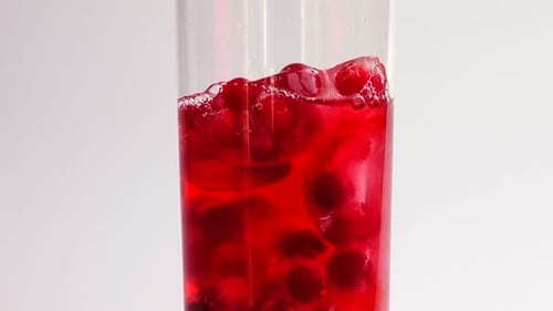 Red Drink Poured into Glass Filled With Ice