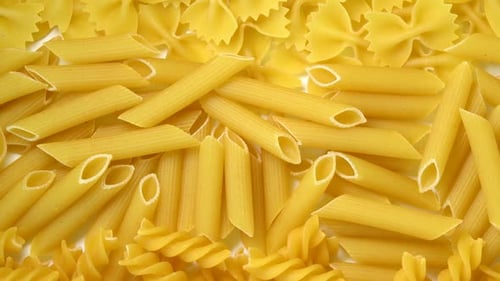 Uncooked mixed kinds of pasta rotating top view