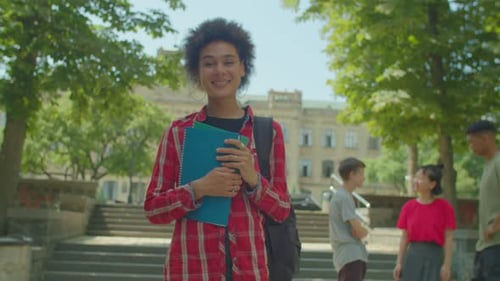 Smiling Student on University Campus with Books