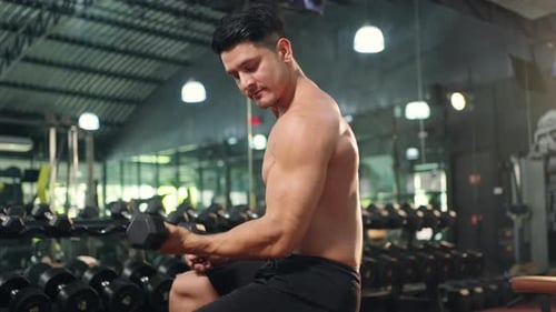 4K Kaukasischer Mann macht Krafttraining beim Hantelheben im Fitnessstudio