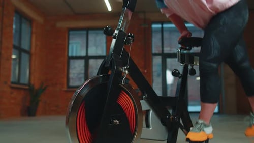 Woman Performs Aerobic Endurance Training Workout Cardio Routine on the Simulators Cycle Training