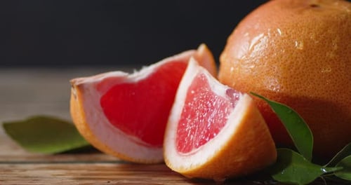 Wet Grapefruit and Slices on Wood Surface