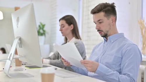 Young Adults Collaborating on Computer at Office Desk