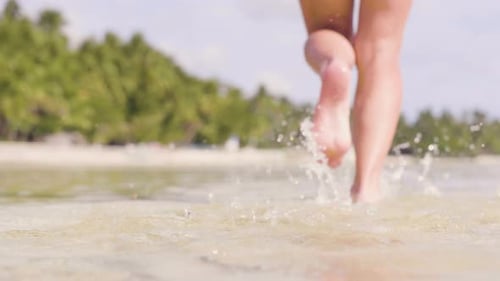 Close Up Female Foot Running on Sea Water at Tropical Beach. Beautiful Woman in Bikini Running on