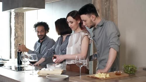 Friends Cooking and Opening Wine in Modern Kitchen