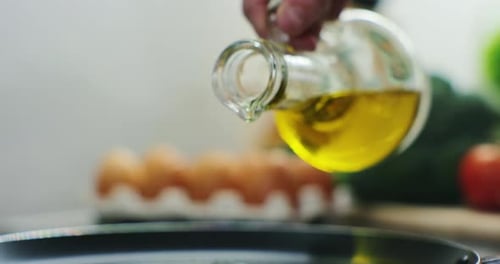 Woman Pours Oil on a Frying Pan on an Electric Stove